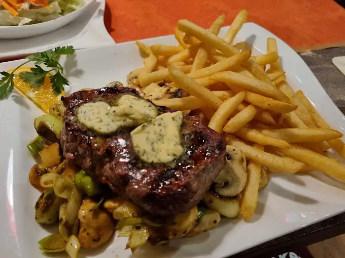 Zartes Steak mit Kräuterbutter und Pommes